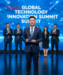 Man in a suit holding an award on stage with a blue backdrop and 'Global Technology Innovation Summit' text.