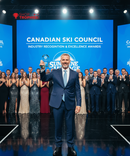 Man holding an award on a stage with 'Canadian Ski Council' backdrop