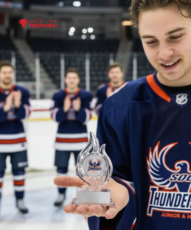 Hockey player holding a trophy with teammates in the background on an ice rink.